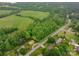 Aerial view showcases a lush green field, mature trees, and charming homes in a serene neighborhood at 2474 Cedar Valley Dr, Conover, NC 28613