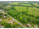 An aerial view showcases a green field, mature trees, and homes in a quiet neighborhood at 2474 Cedar Valley Dr, Conover, NC 28613