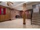 A cozy basement with wood paneling, fireplace and staircase provides ample space for relaxation and entertainment at 2474 Cedar Valley Dr, Conover, NC 28613