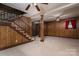 The finished basement is enhanced by wood paneling, a staircase, and a neutral carpet at 2474 Cedar Valley Dr, Conover, NC 28613