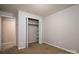 A carpeted bedroom showing a closet with bi-fold doors, offering storage and an adjacent doorway at 2474 Cedar Valley Dr, Conover, NC 28613