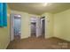 A carpeted bedroom featuring multiple doorways and closets that highlight the space's potential for customization at 2474 Cedar Valley Dr, Conover, NC 28613