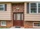 Close-up of front door with brick accents, sidelights, and lighting fixtures at 2474 Cedar Valley Dr, Conover, NC 28613