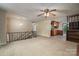 Inviting living room featuring a ceiling fan, staircase, and view into the adjacent kitchen area at 2474 Cedar Valley Dr, Conover, NC 28613