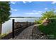 Lakeside backyard featuring stone walkway and panoramic water views, enhanced by lush greenery at 249 Landing Trl, Mount Gilead, NC 27306