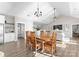 Open-concept dining room featuring a vaulted ceiling, chandelier and wooden table for eight at 249 Landing Trl, Mount Gilead, NC 27306