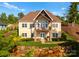 Inviting two-story home with a balcony, stone accents, lush lawn, and beautiful landscaping at 249 Landing Trl, Mount Gilead, NC 27306
