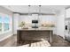 Modern kitchen with shaker cabinets, island with bar seating, and stainless-steel appliances at 249 Landing Trl, Mount Gilead, NC 27306