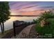 Picturesque stone walkway leading to a waterfront area, framed by lush landscaping and serene water views at 249 Landing Trl, Mount Gilead, NC 27306