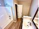 Bathroom featuring a bathtub, sink, toilet, and wooden-look floors at 3032 Mallard Forest Dr, Charlotte, NC 28269