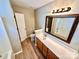 Well-lit bathroom featuring a single sink vanity with wooden cabinets and a large framed mirror at 3032 Mallard Forest Dr, Charlotte, NC 28269
