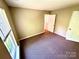Bedroom with carpet flooring, neutral walls, and a large window, along with two entry doors at 3032 Mallard Forest Dr, Charlotte, NC 28269