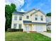 Inviting yellow two-story home features well-manicured lawn and an attached garage at 3032 Mallard Forest Dr, Charlotte, NC 28269
