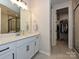 Well-lit bathroom featuring a sleek vanity with a white countertop and a walk-in closet at 306 Cloudcroft Aly, Charlotte, NC 28217