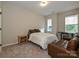 Bright bedroom with carpet flooring, features a comfortable bed and a cozy seating area at 306 Cloudcroft Aly, Charlotte, NC 28217
