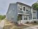 Exterior view of modern townhome featuring gray siding, white trim, and manicured front yard at 306 Cloudcroft Aly, Charlotte, NC 28217
