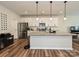 Spacious kitchen featuring stainless steel appliances, white cabinetry, a large center island, and modern lighting at 306 Cloudcroft Aly, Charlotte, NC 28217