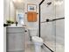 Modern bathroom with a walk-in shower, gray vanity, black fixtures, and orange towels at 316 S Turner Ave # 11, Charlotte, NC 28208