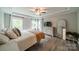 Bright primary bedroom features a tray ceiling, two windows, and a large dresser at 3205 Berry Creek Rd, Charlotte, NC 28214