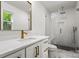 White bathroom with gold fixtures features a seamless glass shower and sleek white cabinets at 3538 Denson Pl, Charlotte, NC 28215
