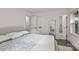A white bedroom with a neutral bed has plenty of natural light and access to a walk-in closet and bathroom at 3538 Denson Pl, Charlotte, NC 28215