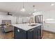 Modern kitchen boasts a navy island with a sink and white countertops, complemented by stainless steel appliances at 3538 Denson Pl, Charlotte, NC 28215