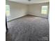 A large bedroom with neutral paint, plush carpeting and natural light at 4048 Avis Way, Monroe, NC 28110