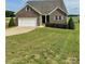Charming brick home featuring an attached two-car garage and a well-maintained, expansive lawn at 4048 Avis Way, Monroe, NC 28110