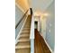 Well-lit hallway featuring carpeted stairs, wood-look flooring, and neutral color scheme at 4048 Avis Way, Monroe, NC 28110