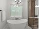 Bathroom featuring stand alone tub, wood storage cabinet, and marble flooring at 4135 Mineral Ln, Lincolnton, NC 28092
