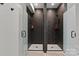 Modern bathroom with dual walk-in showers, each with a dark tiled backsplash and glass doors at 4135 Mineral Ln, Lincolnton, NC 28092
