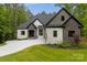 Beautiful modern home featuring a mix of white and stone facade, complemented by a well-manicured lawn at 4135 Mineral Ln, Lincolnton, NC 28092
