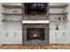 Elegant stone fireplace with floating shelves and white cabinets on either side for storage at 4135 Mineral Ln, Lincolnton, NC 28092