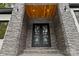 Close-up of the stone entryway with stylish double doors and modern lighting fixtures at 4135 Mineral Ln, Lincolnton, NC 28092