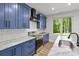 This kitchen features blue cabinets, stainless steel appliances, modern countertops, and a sun-filled window at 4135 Mineral Ln, Lincolnton, NC 28092