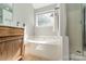 Bathroom featuring a large tub, walk-in shower, and vanity with natural lighting at 4201 Beauvista Dr, Charlotte, NC 28269