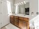 Bright bathroom with double vanity, wood cabinets, large mirror, and white plush rug at 4201 Beauvista Dr, Charlotte, NC 28269