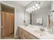 Bright bathroom featuring double sinks, a large mirror with lighting, and a shower with curtain at 4201 Beauvista Dr, Charlotte, NC 28269
