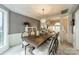 Bright dining room features a modern chandelier over a wooden table with seating for eight at 4201 Beauvista Dr, Charlotte, NC 28269
