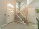 Inviting two-story foyer with a carpeted staircase, decorative railing, and ample natural light from the arched window at 4201 Beauvista Dr, Charlotte, NC 28269