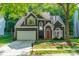 Charming two-story home with mature trees, well-manicured lawn, and a welcoming red front door at 4201 Beauvista Dr, Charlotte, NC 28269