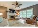 Comfortable living room with a fireplace, TV, large windows with view, and ceiling fan at 4201 Beauvista Dr, Charlotte, NC 28269