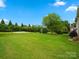 Expansive backyard featuring a basketball court, lush green lawn, and mature landscaping at 422 Deer Brush Ln, Waxhaw, NC 28173