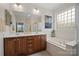 Well-lit bathroom with double vanity, soaking tub, and glass block window at 422 Deer Brush Ln, Waxhaw, NC 28173