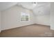 The bonus room has neutral carpet, a window for natural light, and unique ceiling architecture at 422 Deer Brush Ln, Waxhaw, NC 28173