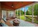 Cozy outdoor seating area on covered porch featuring comfortable seating, ceiling fans, and a view of the backyard at 422 Deer Brush Ln, Waxhaw, NC 28173