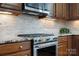 Close up view of a gourmet kitchen range with granite countertops and tiled backsplash at 422 Deer Brush Ln, Waxhaw, NC 28173