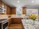 Well-lit kitchen featuring wooden cabinetry, granite countertops, and stainless steel appliances at 422 Deer Brush Ln, Waxhaw, NC 28173