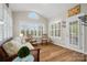 Bright sunroom featuring hardwood floors, large windows, and comfortable seating at 422 Deer Brush Ln, Waxhaw, NC 28173