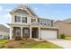 Attractive two-story home featuring a well-manicured lawn, brick accents, and a two car garage at 423 Shallowford Dr, Rock Hill, SC 29732